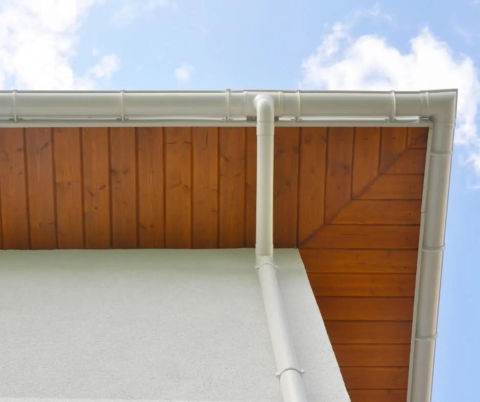 Soffite, fascia et gouttière posés proprement sous un ciel bleu